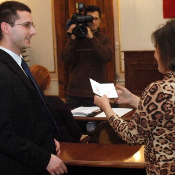 Radosław Fogiel (z lewej) odbiera od wiceprzewodniczącej Rady Jolanty Korpetty &#8211; Zych potwierdzenie złożenia ślubowania i objęcia mandatu radnego.
