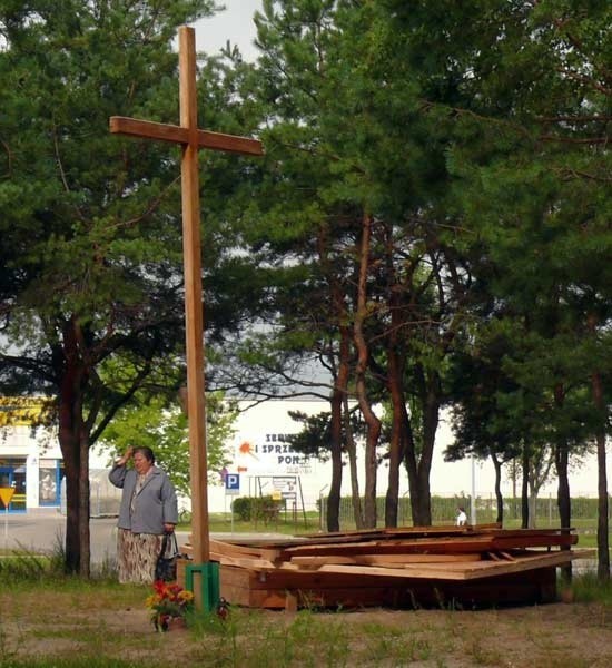 Kapliczka przy krzyżu, zbudowana w miejscu, gdzie ma stanąć kościół, stała się obiektem wandalizmu i w końcu została z niej sterta desek.