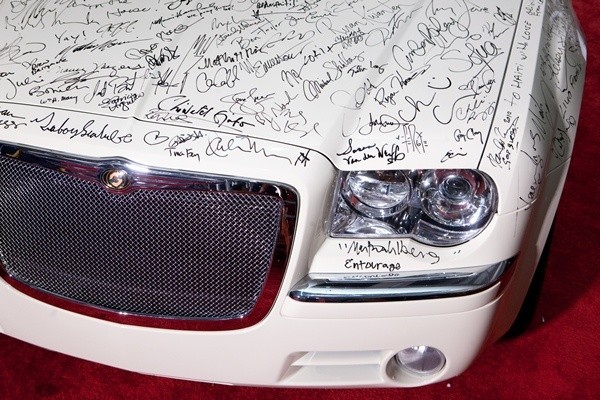 Fragment Chryslera 300C z autografami artystów na lakierze.