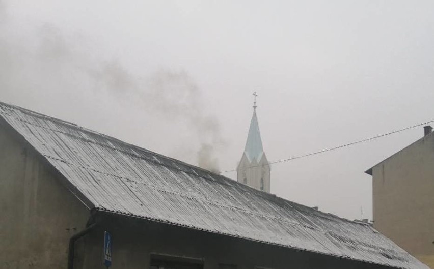 Czarny dym z kominów unoszący się nad Starym Miastem w...
