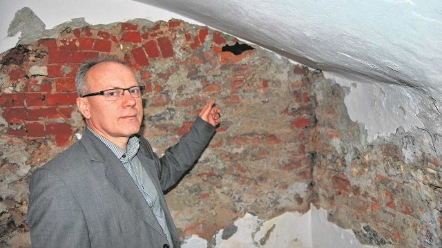 Zbigniew Mazur, dyrektor muzeum, przy ścianie piwnicy, za którą odkryto tajemniczy korytarz