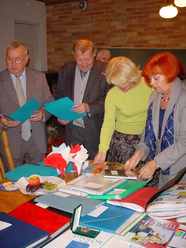Stanisława Giecewicz-Pilarska (z prawej) pokazuje sekretarzowi generalnemu TPPF Edwardowi Sobczakowi (drugi z lewej) wydawnictwa i pamiątkowe albumy opolskiego oddziału.