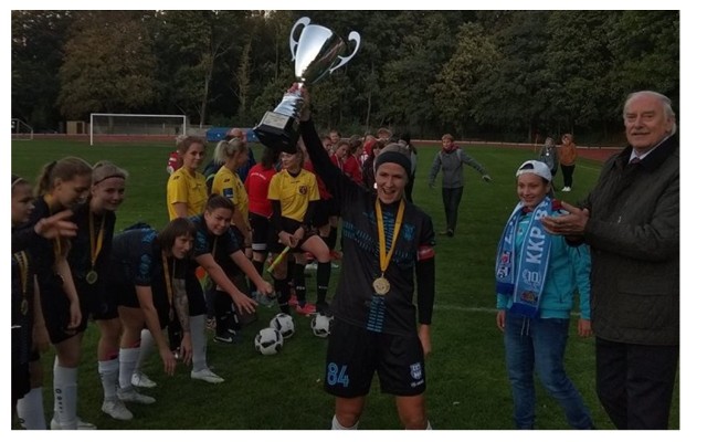 Agata Stępień, kapitan KKP Bydgoszcz, wznosi puchar. Obok Eugeniusz Nowak, wiceprezes PZPN, prezes K-PZPN , który to trofeum wręczał.