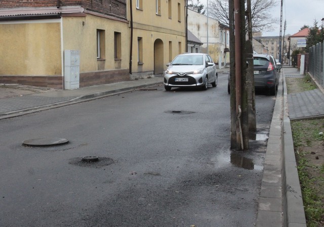 Na ulicy Wrześniowskiego stare słupy energetyczne stoją nadal w jezdni i uniemożliwiają ułożenie ostatniej warstwy asfaltu. Tymczasem jest gotowa nowa linia kablowa i przyłącza do posesji.