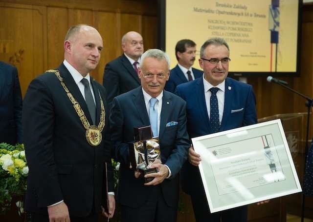 Jarosław Józefowicz (w środku), prezes toruńskich Opatrunków odbiera wyróżnienie dla swojej firmy