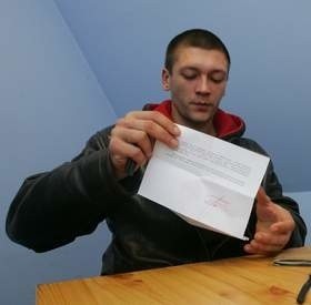 Wiktor pokazuje zezwolenie na pracę otrzymane z Urzędu Wojewódzkiego.