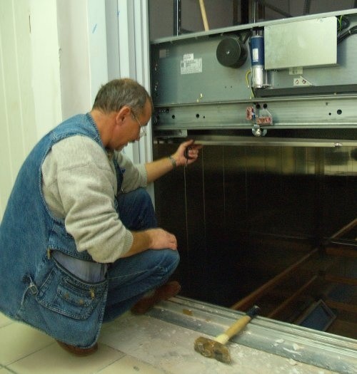 Janusz Owczarzak z koszalińskiego Zakładu Urządzeń Dźwigowych i Elektrotechnicznych sprawdza mechanizm windy.