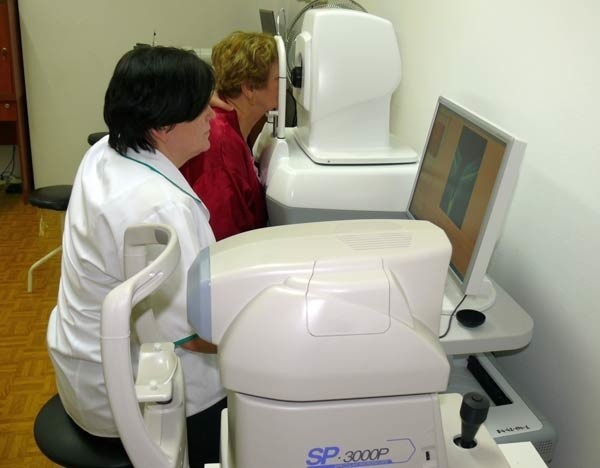 Ordynator Oddziału Okulistycznego dr Alicja Ulewicz bada wzrok pacjentce na tomografie siatkówkowym. Na pierwszym planie aparat do diagnozy rogówki.