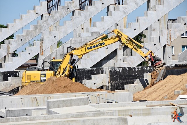 Wczoraj pisaliśmy o tym, że na budowie stadionu Radomskiego Centrum Sportu niewiele się dzieje. Na szczęście prace już zostały wznowione, a Miejski Ośrodek Sportu i Rekreacji opublikował garść zdjęć na których widać, że maszyny wróciły i ekipy budowlane ponownie są na posterunku. "Po wzmocnieniu podłoża pod trybuną północną stadionu piłkarskiego, Generalny Wykonawca wykonuje tzw. zagęszczoną "zasypkę", przygotowując kolejne pola pod montaż prefabrykatów.Zgodnie z zapowiedziami, na plac budowy wróciły również dźwigi, które od rana pracują przy konstrukcji trybun" - czytamy na profilu facebookowym MOSIR.ZOBACZ KOLEJNE ZDJĘCIA Z BUDOWY STADIONU ====>>> 