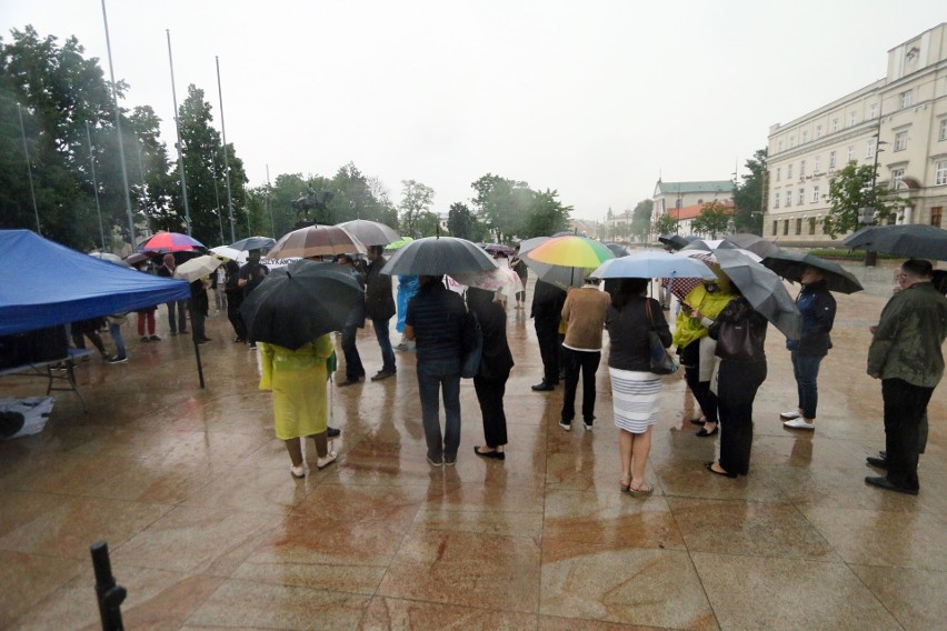 Manifestacja KOD na pl. Litewskim w strugach deszczu