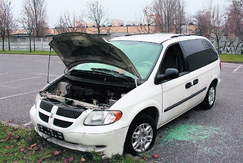 Przy ul. Wydawniczej stoi dodge caravan. Z pojazdu...