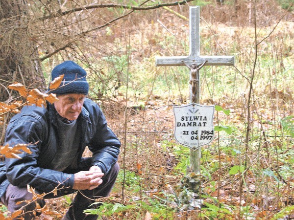 Stanisław Adamczyk przy symbolicznej mogile Sylwii w lesie.