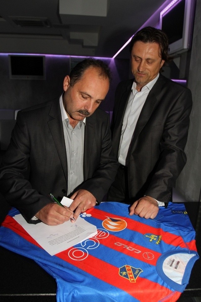Wiceprezes Odry Ireneusz Gitlar (z lewej) i trener Andrzej Polak podpisują umowę.