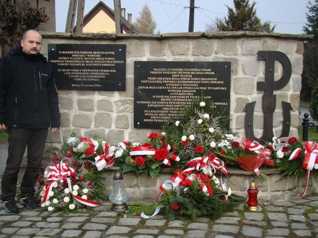 Historyk Marcin Dziubek przed pomnikiem w Bielanach poświęconym oddziałowi AK "Sosienki"