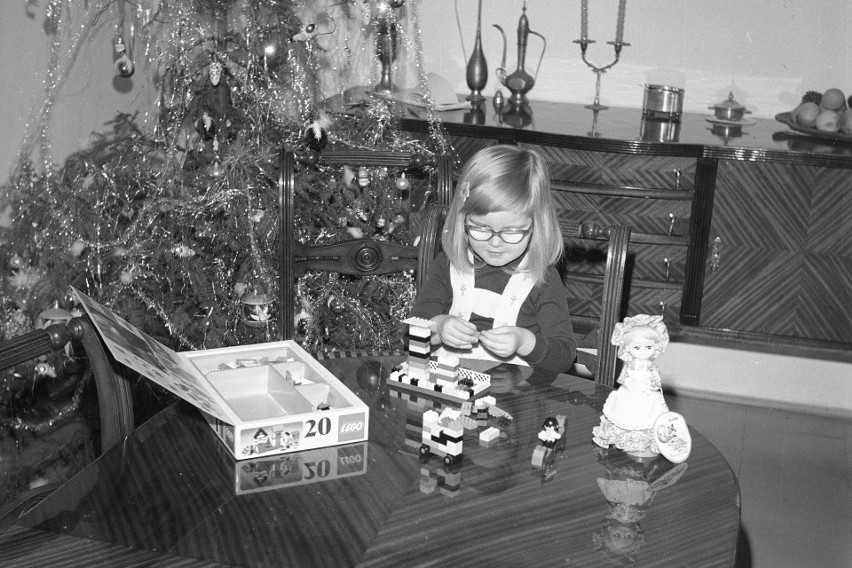 Ewa Spirydowicz bawi się klockami Lego przy stole. W tle...