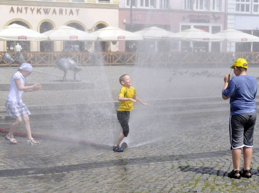 Na Starym Rynku w Bydgoszczy dzieci bawią się w chłodzącej...