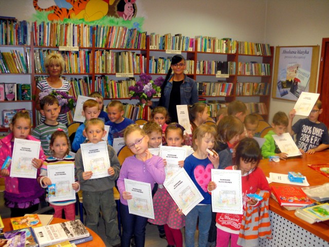 Zadowolone dzieci w wąchockiej bibliotece na pamiątkowym zdjęciu, kończącym spotkanie.