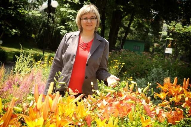 Beata Gęsińska wśród letnich kwiatów bujnie kwitnących w ogrodzie 