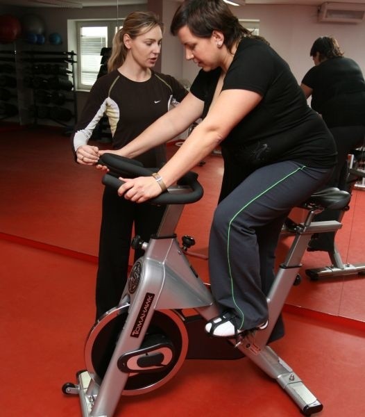 Olga Chaińska, instruktorka fitness, daje pani Eleonorze wskazówki, jaka powinna być pozycja do jazdy na rowerze.