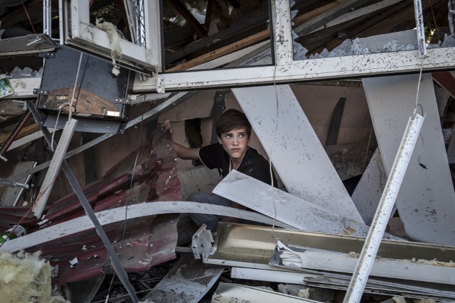 Dziecko w jednym ze zrujnowanych domów w Doniecku