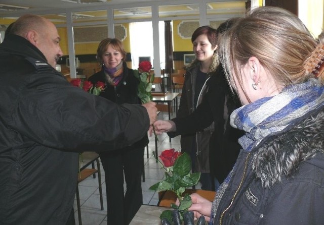 Norbert Maj, naczelnik jędrzejowskiej drogówki, rozdaje paniom róże z okazji ich święta.