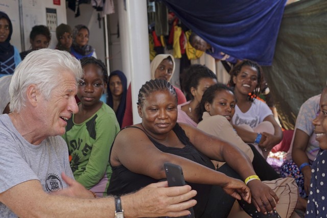 Aktor Richard Gere rozmawia z migrantami na pokładzie statku Open Arms