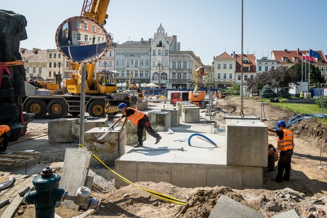 We wtorek Pomnik Walki i Męczeństwa na Starym Rynku został zdjęty z cokołu i powędrował kilkanaście metrów dalej. Na tym nie koniec - monument jeszcze raz zmieni lokalizację. Tymczasem zobaczcie, jak wyglądają prace w sercu miastaPraca na Starym Rynku w Bydgoszczy wre. Wczoraj (wtorek) przeprowadzono niełatwą operację przeniesienia Pomnika Walki i Męczeństwa. Monument został zdjęty z cokołu i dźwigiem przetransportowany kilkanaście metrów dalej. Na tym jednak nie koniec. - To nie jest docelowe miejsce, w którym będzie stał pomnik - mówi Rafał Bruski, prezydent Bydgoszczy. - W najbliższym czasie zostanie jeszcze przesunięty o ok. 5 metrów. Przypomnijmy, przebudowa Starego Rynku trwa od początku lipca. Sama płyta rynku ma być gotowa za parę miesięcy. Jesienią rozpoczną się prace dookoła płyty. Cała inwestycja ma być zrealizowana do czerwca przyszłego roku. Jej koszt to 14 mln zł. Prace  prowadzi bydgoska firma Betpol.Przebudowa Starego Rynku w Bydgoszczy. W lipcu ruszają prace! Co się zmieni? [wizualizacje]FLESZ - letnie upały, jak reagować w razie udaru słonecznego?