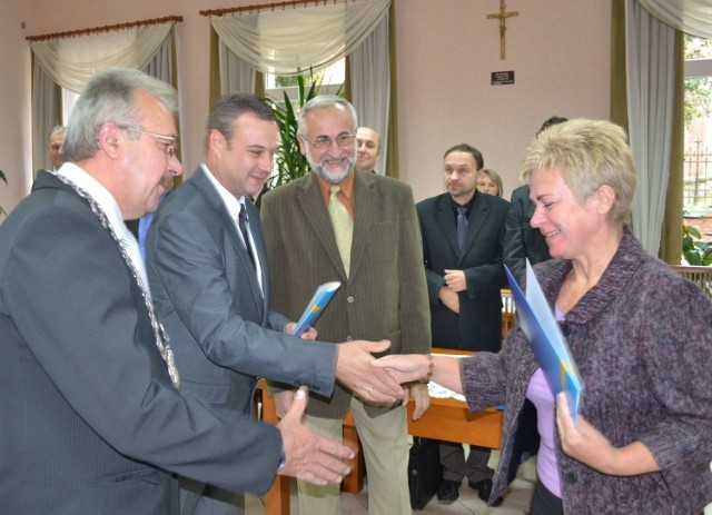 Przewodniczący Rady Wiktor Przybysz, sekretarz  Sebastian Nabrzeski oraz wójt Andrzej Karaś gratulują zwycięzcy.