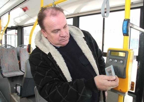 Zbigniew Miernik, kierowca solarisa, demonstruje sposób skanowania Kieleckiej Karty Miejskiej w nowym czytniku.