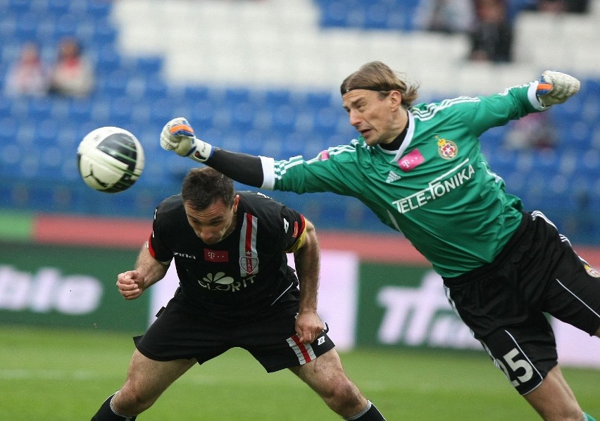 Marek Saganowski w starciu z bramkarzem Wisły.