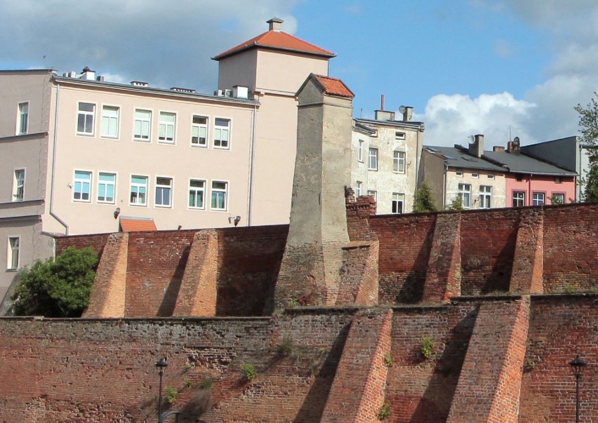 Wieżyczka wodociągowa wznosząca się nad murami miejskimi...