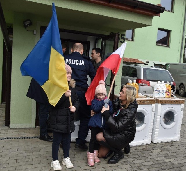 Przekazanie pralek, zakupionych przez wielicką Komendę Powiatową Policji dla ośrodka dla uchodźców w Grabiu pod Wieliczką. Darczyńcom asystowały dzieci z Ukrainy z flagami Polski i Ukrainy