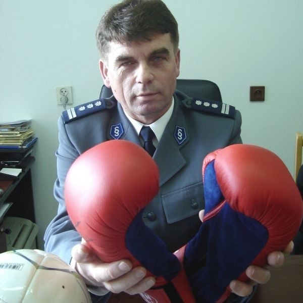 Komendant Andrzej Chaniecki pokazuje rękawice podpisane przez Agnieszkę Rylik, mistrzynię świata w boksie. Obok piłka z autografem bramkarza Jerzego Dudka.