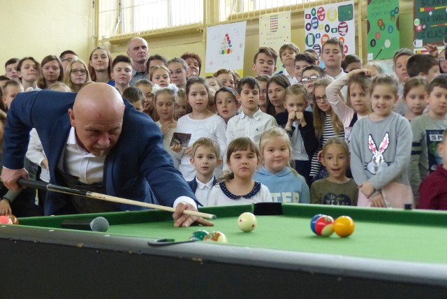 W Szkole Podstawowej numer 1 imienia Stanisława Staszica w Kielcach uroczyście otwarto ośrodek bilardowy.  W tym wydarzeniu uczestniczyli między innymi Renata Janik - wicemarszałek województwa świętokrzyskiego, Marcin Różycki - wiceprezydent Kielc, Kazimierz Mądzik - świętokrzyskiego kuratora oświaty, Joanna Winiarska - wiceprzewodnicząca Rady Miasta w Kielcach, radna Anna Kibortt, Grzegorz Kędzierski - prezes zarządu Polskiego Związku Bilardowego, Bogdan Wołkowski - wielokrotny mistrz świata w trikach bilardowych, mistrz Polski Michał Turkowski, Alicja Stradomska - prezes wojewódzkiego Szkolnego Związku Sportowego w Kielcach, prezes Wodociągów Kieleckich Henryk Milcarz. -Do użytku oddajemy dziś dwa pełnowymiarowe stoły bilardowe z myślą o tym, że od 1 września przyszłego roku w naszej szkole powstanie klasa bilardowa. Wystąpiłam o dodatkowe zajęcia dla naszych uczniów, będą prowadzone między innymi przez bilardowego mistrza Polski Michała Turkowskiego. Nasza młodzież będzie brała udział w turniejach bilardowych, to będzie dla niej ciekawa alternatywa do spędzania wolnego czasu - mówiła dyrektor szkoły Żaneta Szczepaniak. -Przyjaciółmi jesteśmy wszyscy, którzy kochają bilard. To jest sport, który uczy koncentracji i strategii. A mistrzem strategii jest obecny tu Grzegorz Kędzierski, który na wielu turniejach mówił mi: Marcin, usiądź sobie na chwile, poczekaj, niech się twój przeciwnik zdenerwuje. I zdawało to egzamin  - mówił Marcin Różycki, wiceprezydent Kielc. -Chciałbym, żebyście pokochali ten sport, tak jak wiele osób. Pamiętam Oliwię Czupryńską. Jak grała z nami, musiała sobie podstawiać pudełko, żeby dostać do stołu. Teraz jest wicemistrzynią Europy i tak naprawdę nie chciałbym się z nią teraz zmierzyć (śmiech). Kochani, grajcie w bilard, bo jest to piękny sport - dodał. Podczas uroczystości nagrodzono laureatów konkursu plastycznego "Bilardowa Jedynka". Później odbył się ciekawy pojedynek bilardowy pomiędzy wiceprezydentem Kielc Marcinem Różyckim i uczniem szkoły Wiktorem Wichą. -Proponuje remis. Zgadzasz się? - zapytał po kilku minutach wiceprezydent swojego przeciwnika. -Tak - odpowiedział Wiktor. Na zakończenie pokaz trików bilardowych dał Bogdan Wołkowski i jego zagrania zostały owacyjnie przyjęte przez liczna grupę uczniów szkoły uczestniczących w tym wydarzeniu i zaproszonych gości.   Dorota Kułaga