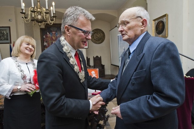 Jan Skórski (z prawej), pionier Darłowa,  odbiera od burmistrza Arkadiusza Klimowicza gratulacje i pamiątkową monetę.