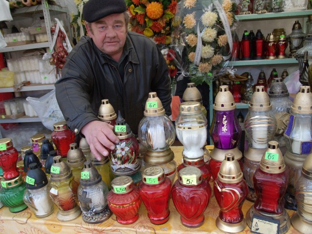 Stanisław Burdecki sprzedaje znicze przed koszalińskim cmentarzem. Oferuje też kwiaty i stroiki, wszystko - zapewnia - w przystępnych cenach.