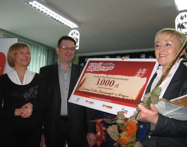 Dyrektorka szkoły Alina Rapacz (z prawej) odbiera symboliczny czek od Marioli i Waldemara Wicińskich