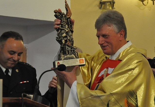 Ksiądz Jan Podsiadło, kapelan strażaków, otrzymał od powiatowego komendanta straży Romana Borunia statuetkę św. Floriana