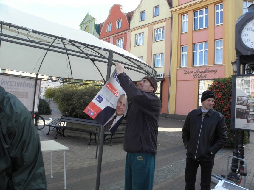 Marcin Wałdoch wiesza wyborcze plakaty na stoisku PiS