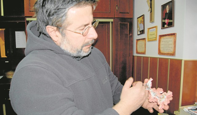 Konserwator Roman Krzyżewski przygotowuje fragment ornamentu gzymsu do złocenia poprzez gruntowanie