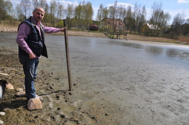 Tadeusz Osiecki demonstruje obecny stan wody w jeziorze w Sępólnie Małym.