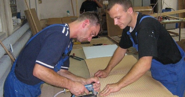 Robert Wachoński (z lewej) i Marcin Sokołowski obijają tkaniną loomową element łóżka