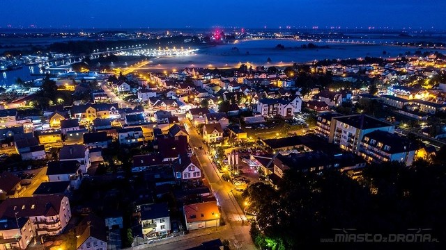 Kolejną porcję zdjęć lotniczych zaprezentował na swojej stronie Sebastian Kołodziejek. Fotografie przedstawiają nadmorskie Darłowo z nieco innej perspektywy. Na zdjęciach widać przede wszystkim port morski w Darłówku, wpływające i wypływające statki,  czy górujący apartamentowiec Marina Royale. Dodatkowo tym razem zamieszczamy również zdjęcia wykonane wieczorem. Pokazują one uroczy klimat Darłówka. Jest też fotografia przedstawiająca darłowski rynek w dzień. Widać na niej rzędy kamienic, rzekę Wieprzę, a w oddali nawet dawny elewator zbożowy i oczywiście Morze Bałtyckie. Zdjęcia są widowiskowe. Po więcej zapraszamy na stronę www.miastozdrona.pl;nf. Sebastian Kołodziejek pochodzi ze Zduńskiej Woli,  ale od kilku lat regularnie odwiedza Darłowo. Jego panoramiczne fotografie przedstawiające darłowskie plaże można oglądać także na fanpage ,,Miasto z drona” na Facebooku.  Zobacz także Festiwal Szantowy w Darłowie 