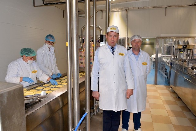 Od lewej Ryszard Pizior, prezes włoszczowskiej spółdzielni oraz Marcin Cieślikiewicz, kierownik działu konfekcjonowania sera, prezentują najnowocześniejszą na rynku linię do plasterkowania i pakowania.