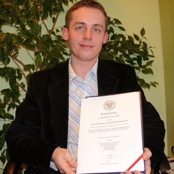 Roman Niwierski z wyróżnieniem, jakie otrzymał za prace magisterską od Instytutu Pamięci Narodowej.