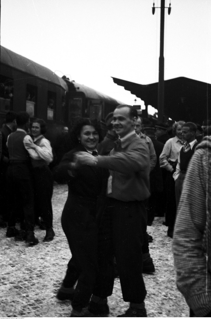 Pasażerowie pociągu narty-dancing-brydż tańczą na stacji....