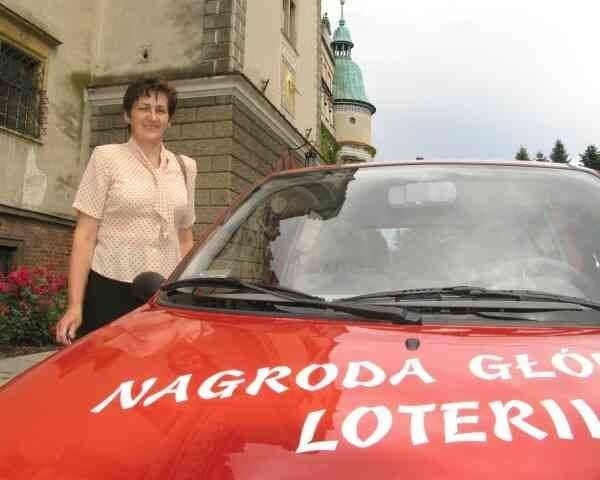 Grażyna Bątorek z Woli Rusinowskiej w powiecie kolbuszowskim z wylosowanym samochodem, przed Zamkiem w Baranowie Sandomierskim.