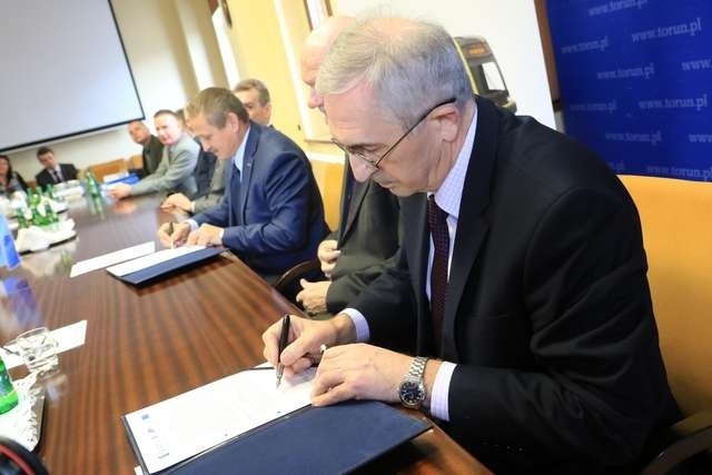 Janusz Szymański (z prawej) i Tomasz Zaboklicki (w tle) podpisują umowę na zakup nowych swingów