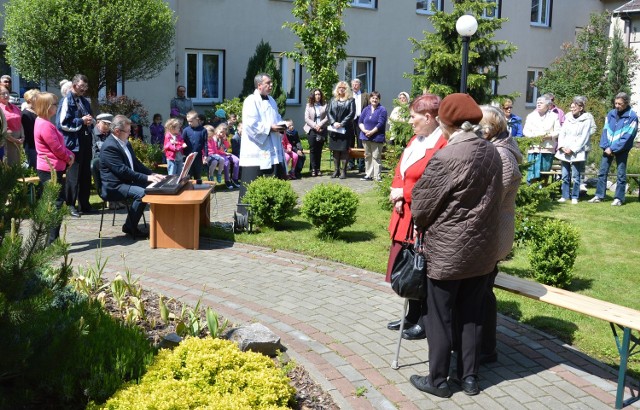 Nabożeństwo majowe w ogrodzie Domu Pomocy Społecznej, przed drewnianą kapliczką z postacią Matki Boga.