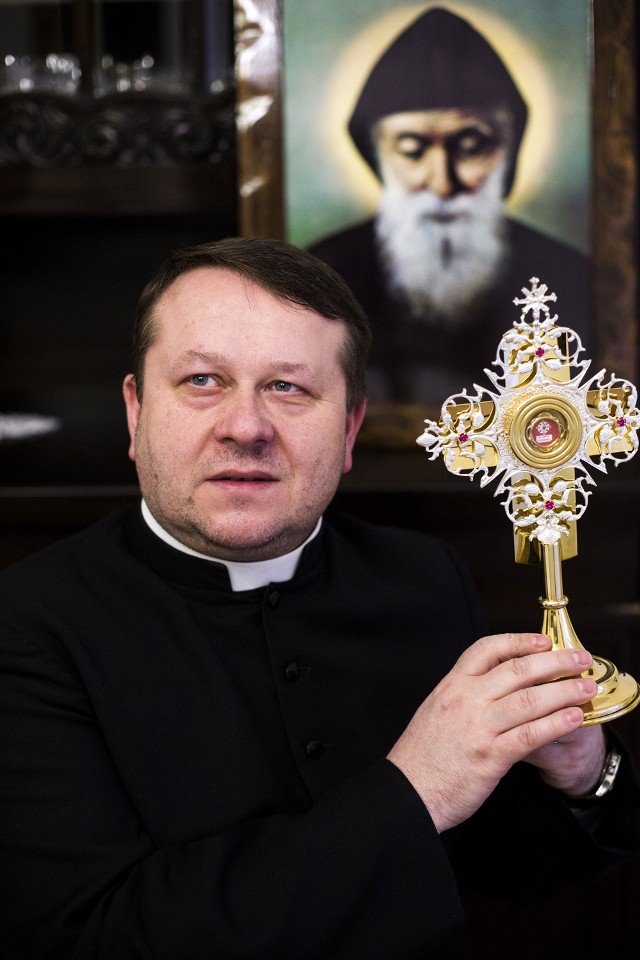 Ks. Paweł Kubani z relikwiami, w tle wizerunek świętego.